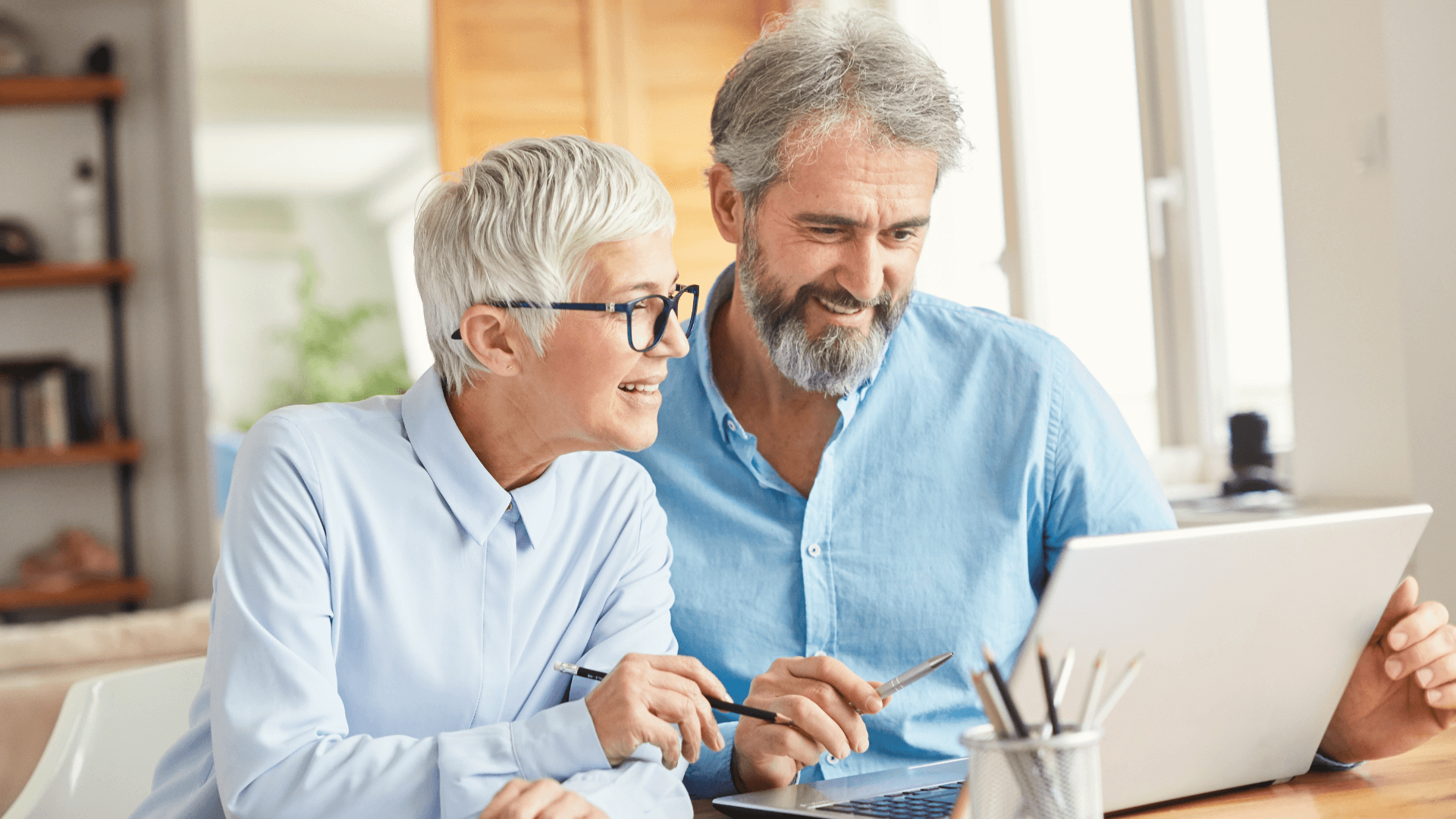 woman and man sitting at desk looking at laptop